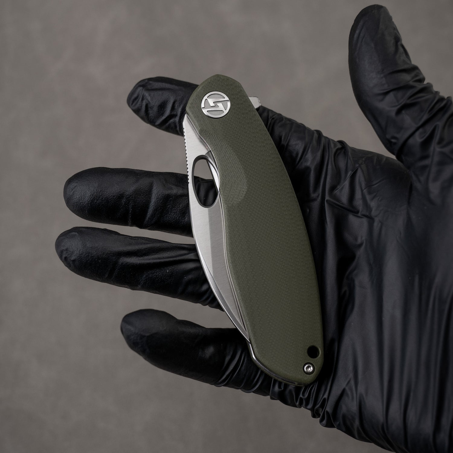 Closed G064 in hand – green handle, satin edge